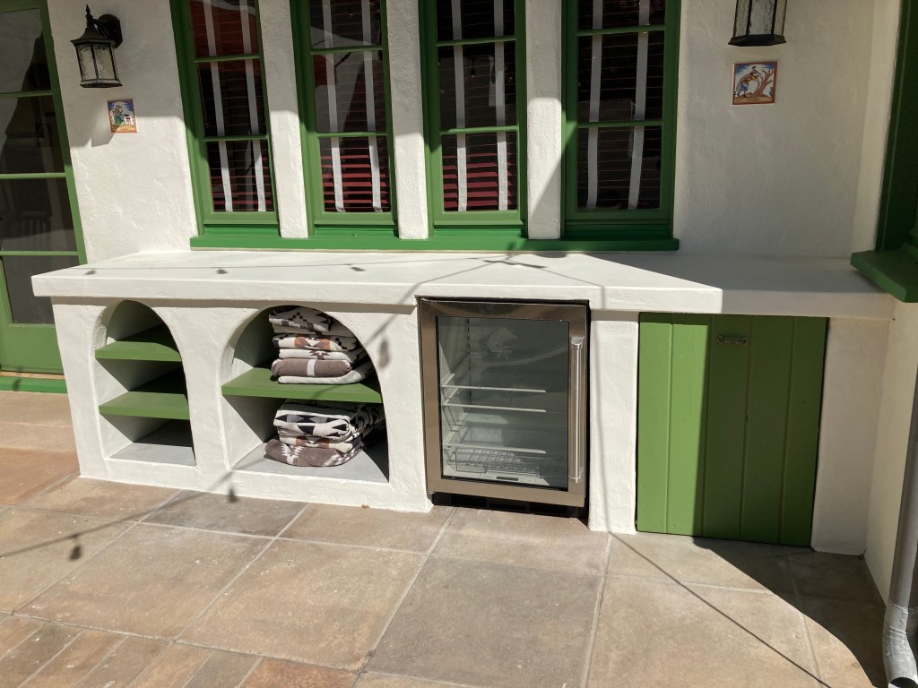 Outdoor service area with drink refrigerator to match existing architectural components.
